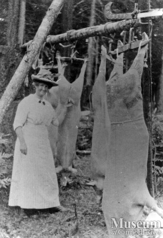 Mrs. James A. Nixon of Twin Islands with slaughtered pigs