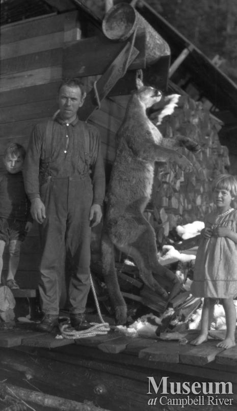 August Schnarr with children on his porch with dead cougar 1920's