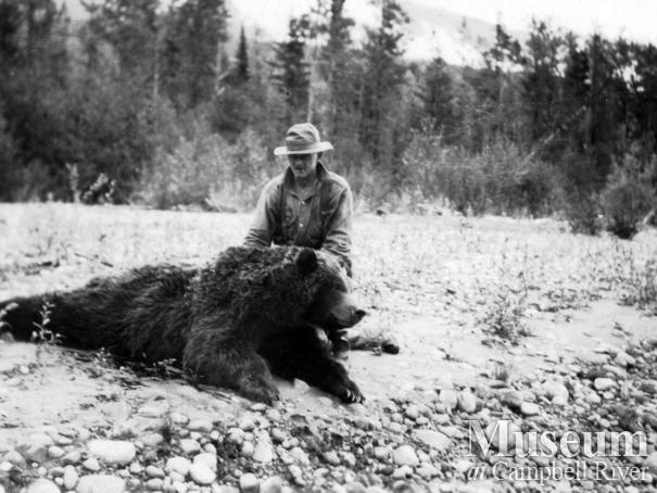 Jim Stanton with dead grizzly bear, Knight Inlet, B.C.