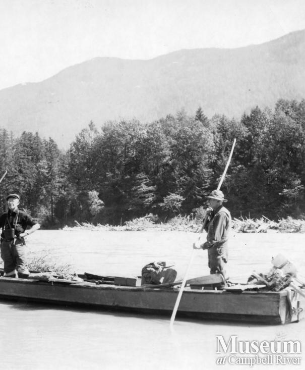 Two men poling up the Kleena Kleene River at the head of Knight Inlet